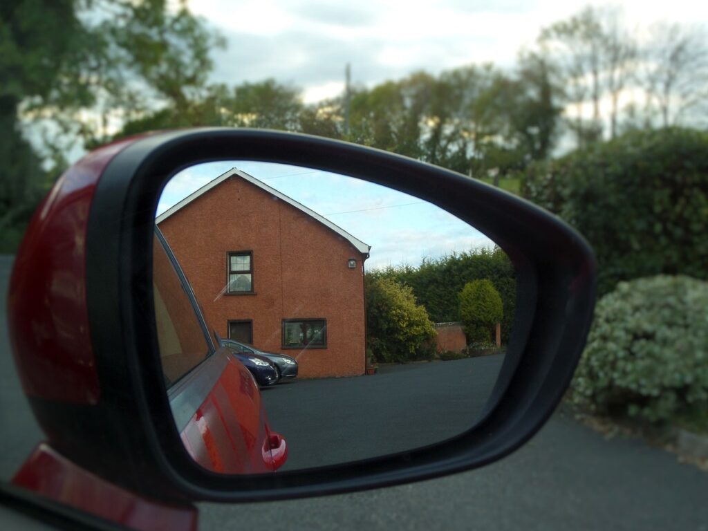 Looking at a car review mirror reflecting what is behind the car.