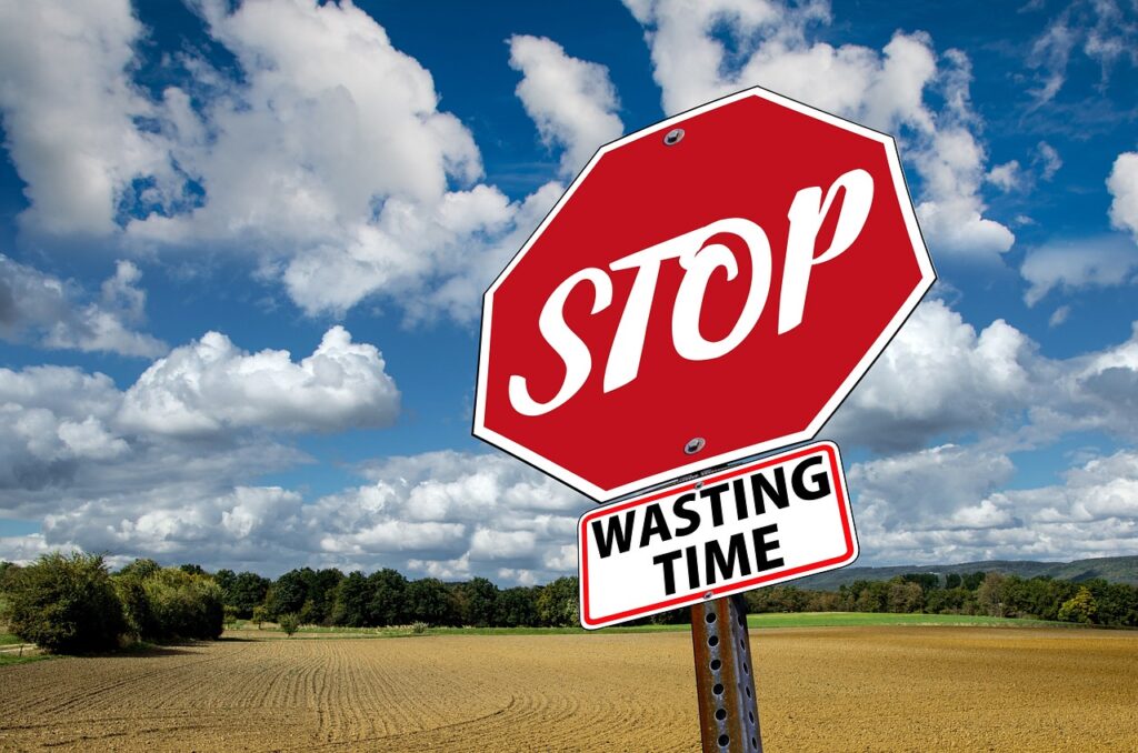 Stop Sign with a sign below it saying Wasting Time.