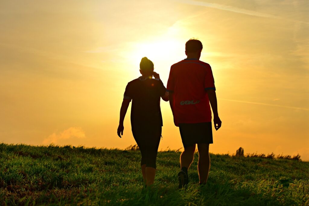 Couple walking toward a sunset.