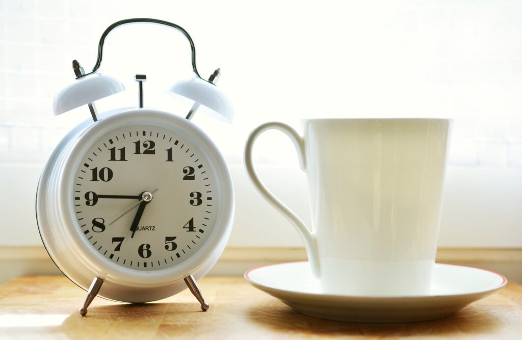 Alarm clock next to a coffee cup