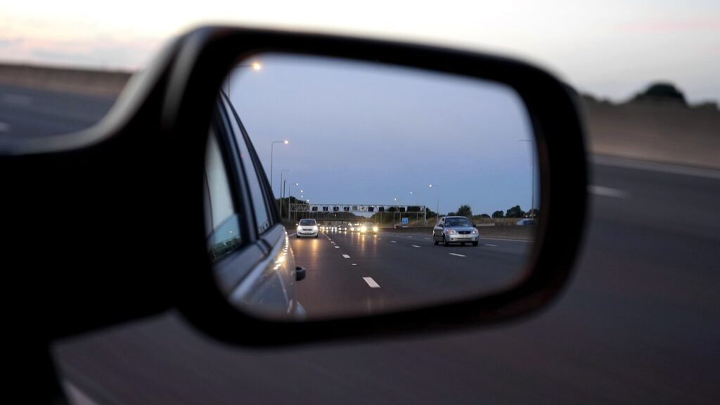 Traffic in a rear-view mirror.