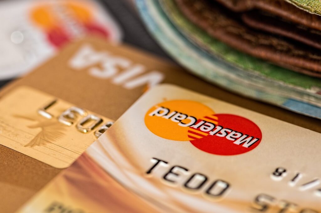 A Master Card and a VISA credit cards laying on a table.