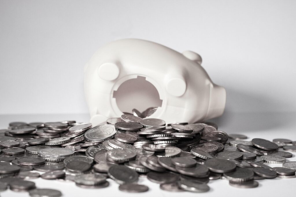 Piggy bank on its side with money spilling out from its belly.