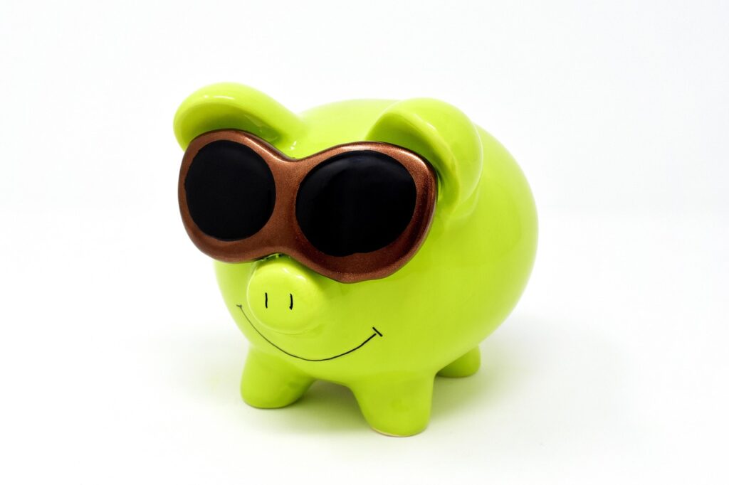 A yellow piggy bank with a smile and sun glasses.