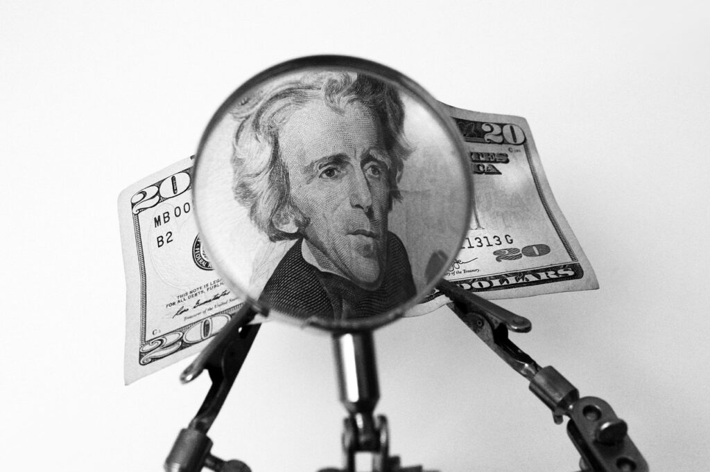 A $20 bill under a magnifying glass.