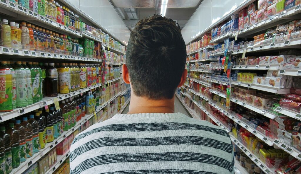 Man looking down a grocery aisle.