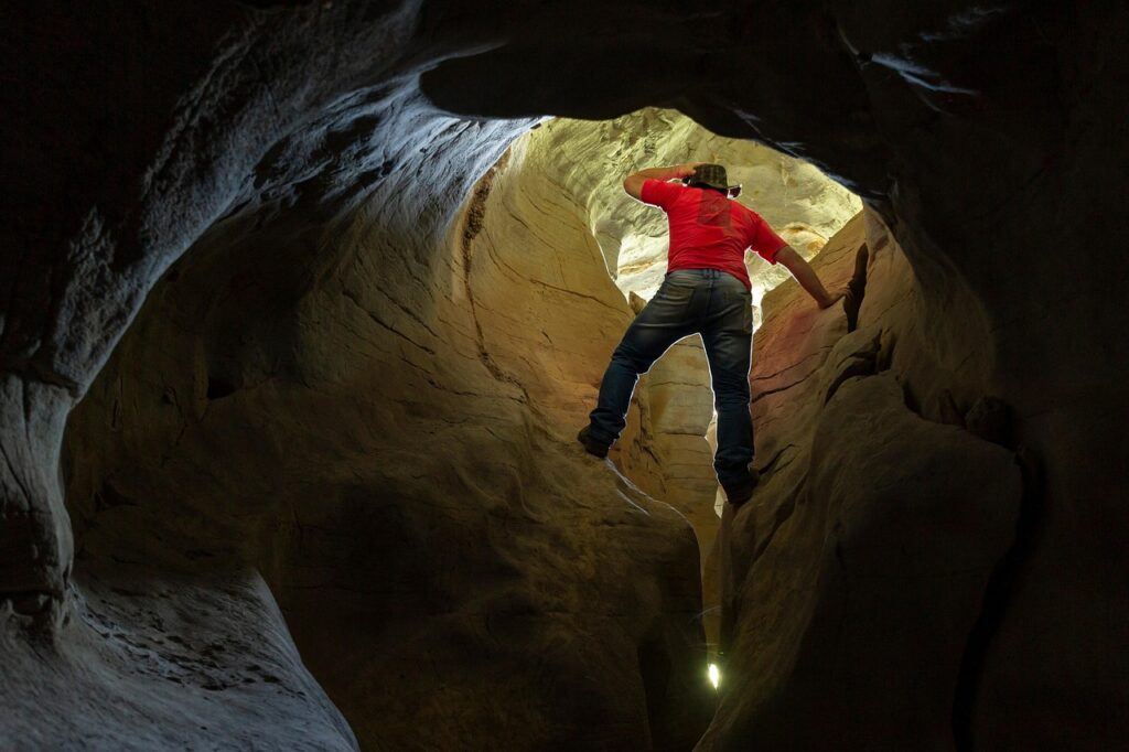 Man climbing out of a cave.