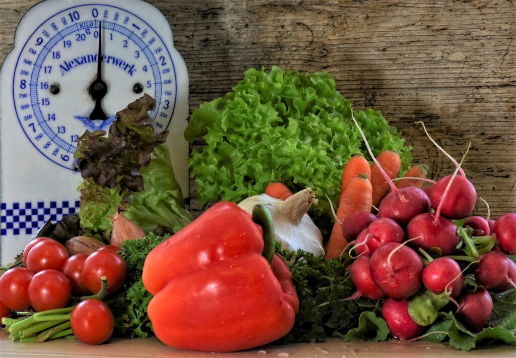 A selection of vegetables in front of a food scale.