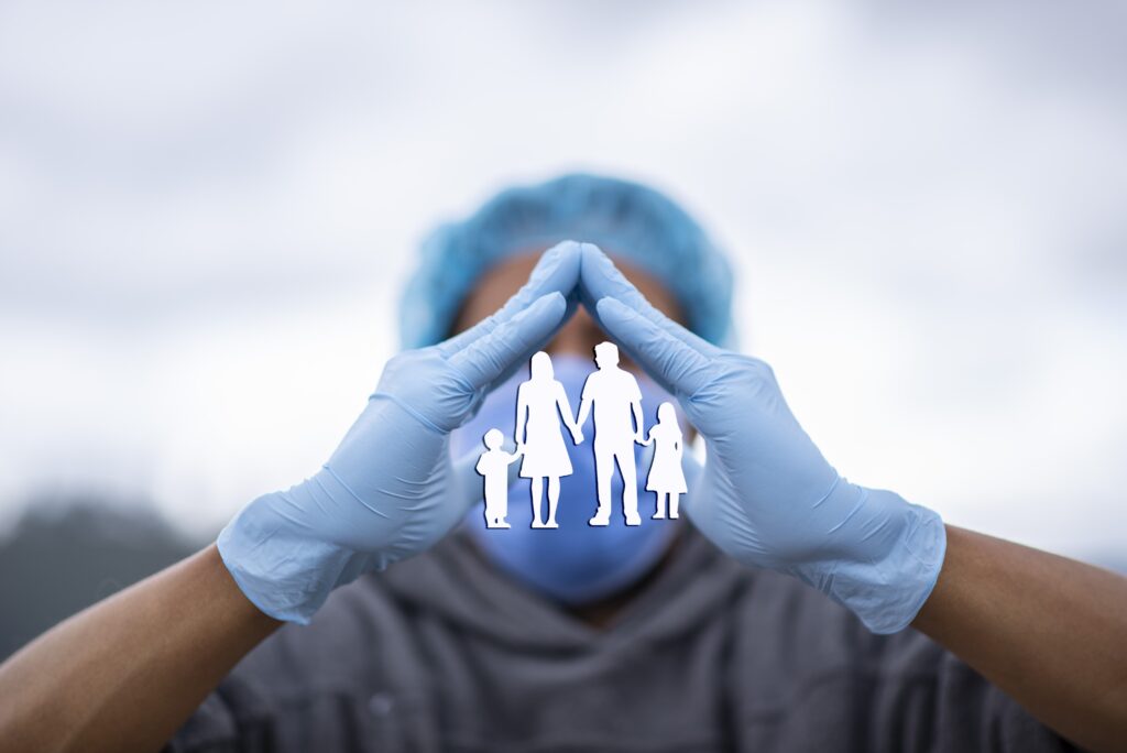 Medical person sheltering an image of a family with their hands.