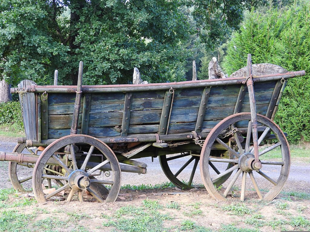 Old wagon with wheels buried in a few inches of dirt.