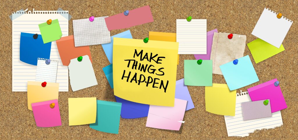 A bulletin board with sticky notes pinned on it with a sign that says "Make Things Happen!"